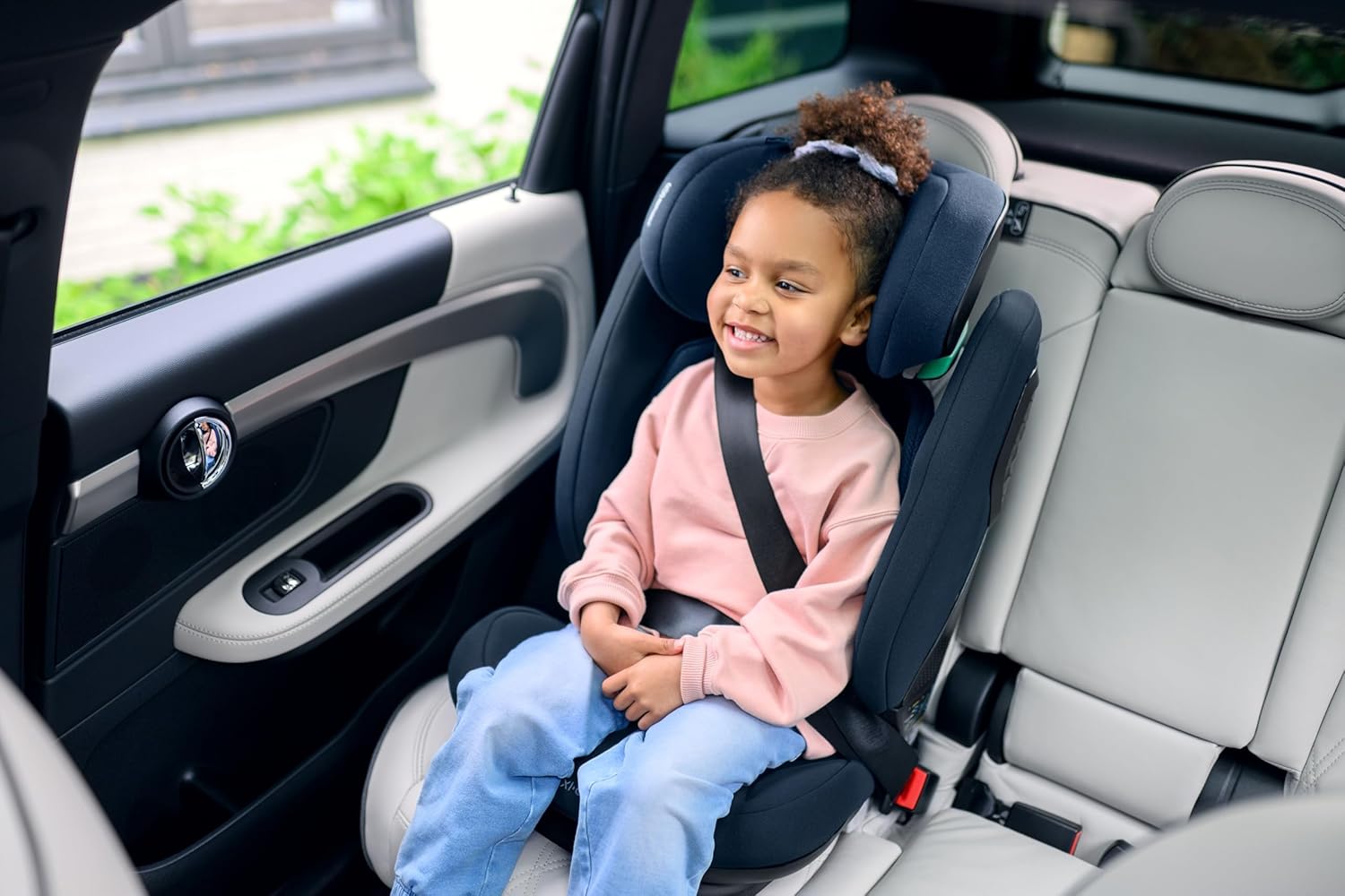 Niña sentada en la silla de coche Maxi-Cosi RodiFix Pro 2 i-Size utilizando el cinturón de seguridad del vehículo